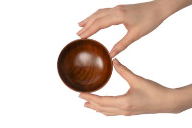 Kadın eli beyaz arka planda izole edilmiş ahşap bir kase tutuyor.. 