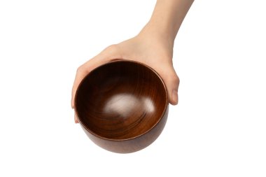 Kadın eli beyaz arka planda izole edilmiş ahşap bir kase tutuyor.. 