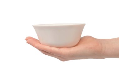 Kadın eli beyaz bir arka planda izole edilmiş seramik bir kase tutuyor.. 