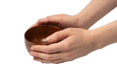 Kadın eli beyaz arka planda izole edilmiş ahşap bir kase tutuyor.. 