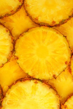 Arka plan olarak ananas sulu sarı dilimler. Üst görünüm.
