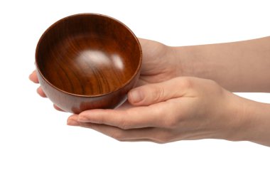 Kadın eli beyaz arka planda izole edilmiş ahşap bir kase tutuyor.. 