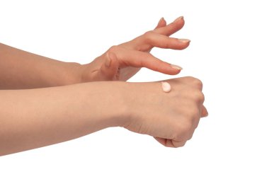 Beyaz arka planda izole edilmiş kadın ellerinde bej krem tüpü. Kadın elinin üzerindeki krema örneği. Cilt bakımı kavramı.