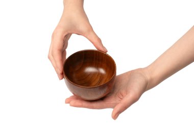 Kadın eli beyaz arka planda izole edilmiş ahşap bir kase tutuyor.. 