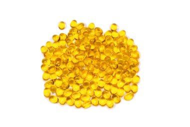 Beyaz zemin üzerinde izole edilmiş bir grup sarı kapsül. 