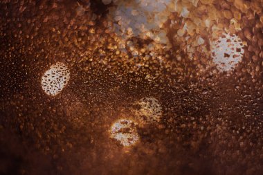 Yağmur damlaları ve ışıklarla bulanık arkaplan.