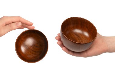 Kadın eli beyaz arka planda izole edilmiş ahşap bir kase tutuyor.. 