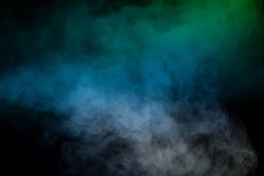 Siyah arka planda mavi ve yeşil buhar. Boşluğu kopyala.