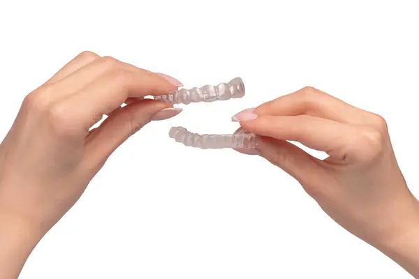 stock image Transparent mouth guard in a woman's hand isolated on a white background. 