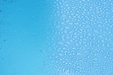 Mavi bardakta su damlası. Islak cam. Boşluğu kopyala. 