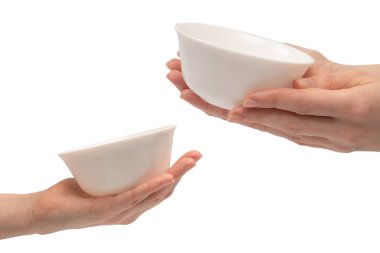 Kadın eli beyaz bir arka planda izole edilmiş seramik bir kase tutuyor.. 