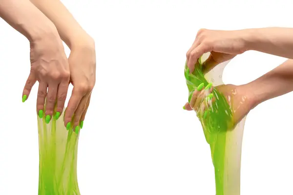 stock image Green slime toy in woman hand with green nails isolated on a white background. 