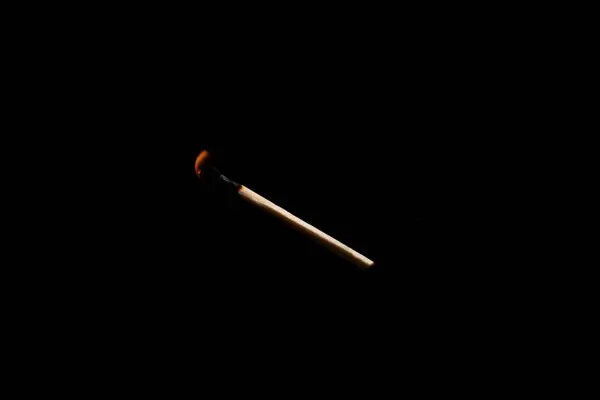 stock image Lit and falling match on a black background.