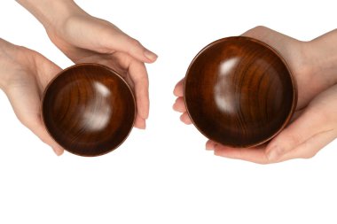 Kadın eli beyaz arka planda izole edilmiş ahşap bir kase tutuyor.. 