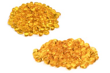 Beyaz zemin üzerinde izole edilmiş bir grup sarı kapsül. 