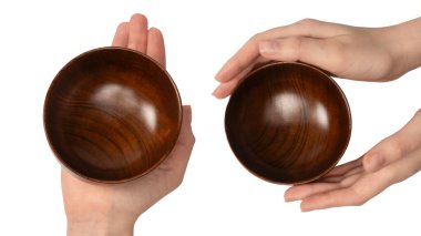 Kadın eli beyaz arka planda izole edilmiş ahşap bir kase tutuyor.. 