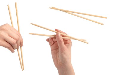 Beyaz arka planda izole edilmiş ahşap suşi çubuklarını tutan kadın.. 