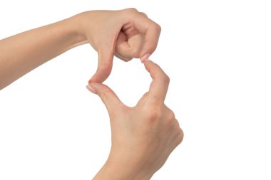 Kadın elleri, beyaz arka planda izole edilmiş parmaklarla işaret kalp sembolü yapıyor..