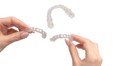 Transparent mouth guard in a woman's hand isolated on a white background.  clipart