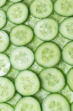 Arka plan olarak taze yeşil salatalık dilimleri. Üst görünüm. 