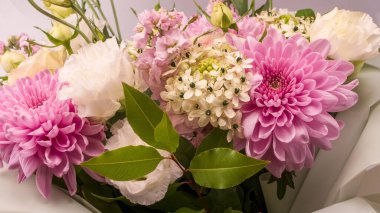 Üzerinde pembe güller, kasımpatı ve frezya çiçeği olan bir buket çiçek beyaz bir arka planda izole edilmiş vazoda.. 