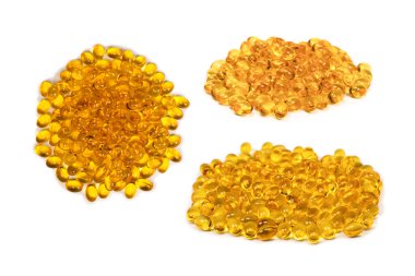 Beyaz zemin üzerinde izole edilmiş bir grup sarı kapsül. 