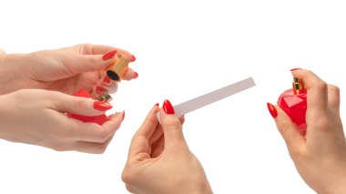 Beyaz arka planda kırmızı tırnaklı bir kadın elinde kırmızı parfüm şişesi. Boşluğu kopyala. 