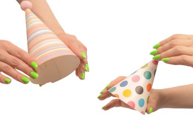 Beyaz arka planda izole edilmiş kadınların ellerinde renkli bir doğum günü şapkası.