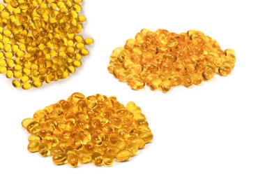 Beyaz zemin üzerinde izole edilmiş bir grup sarı kapsül. 