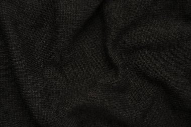 Arka plan olarak koyu gri süveter dokusu. Örgü desenli. Üst görünüm. 