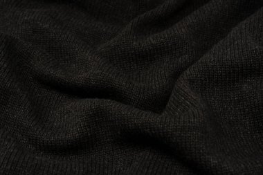 Arka plan olarak koyu gri süveter dokusu. Örgü desenli. Üst görünüm. 