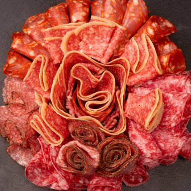 Tahtada farklı et parçaları var. Siyah bir arkaplanda.