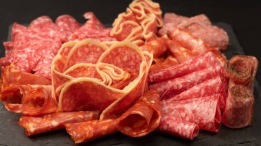 Tahtada farklı et parçaları var. Siyah bir arkaplanda.