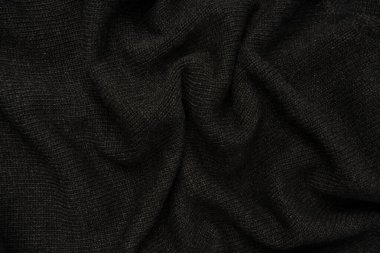 Arka plan olarak koyu gri süveter dokusu. Örgü desenli. Üst görünüm. 