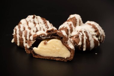 Siyah arka planda hindistan cevizi kremalı profiterol.. 