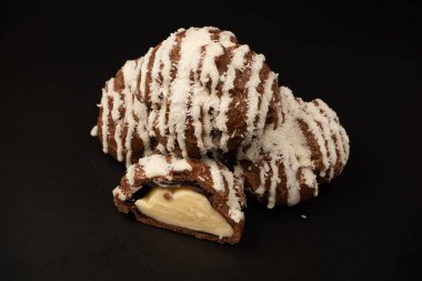 Siyah arka planda hindistan cevizi kremalı profiterol.. 
