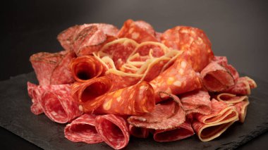 Tahtada farklı et parçaları var. Siyah bir arkaplanda.