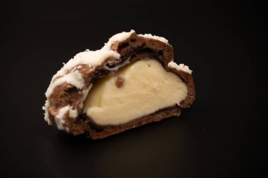 Siyah arka planda hindistan cevizi kremalı profiterol.. 