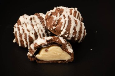 Siyah arka planda hindistan cevizi kremalı profiterol.. 