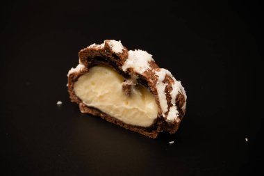 Siyah arka planda hindistan cevizi kremalı profiterol.. 