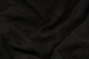 Arka plan olarak koyu gri süveter dokusu. Örgü desenli. Üst görünüm. 