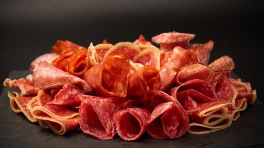 Tahtada farklı et parçaları var. Siyah bir arkaplanda.