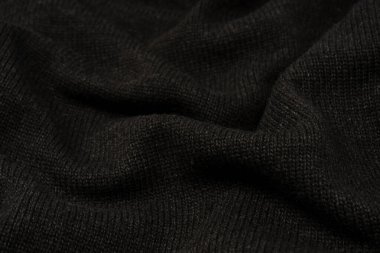 Arka plan olarak koyu gri süveter dokusu. Örgü desenli. Üst görünüm. 