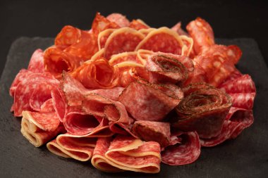 Tahtada farklı et parçaları var. Siyah bir arkaplanda.