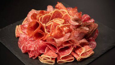 Tahtada farklı et parçaları var. Siyah bir arkaplanda.