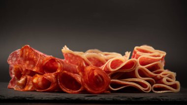 Tahtada farklı et parçaları var. Siyah bir arkaplanda.