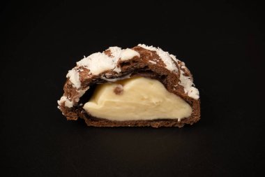 Siyah arka planda hindistan cevizi kremalı profiterol.. 