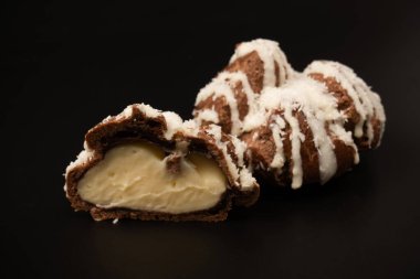 Siyah arka planda hindistan cevizi kremalı profiterol.. 