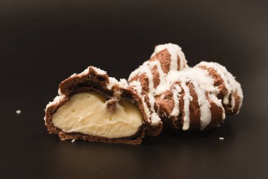 Siyah arka planda hindistan cevizi kremalı profiterol.. 