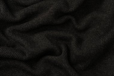 Arka plan olarak koyu gri süveter dokusu. Örgü desenli. Üst görünüm. 